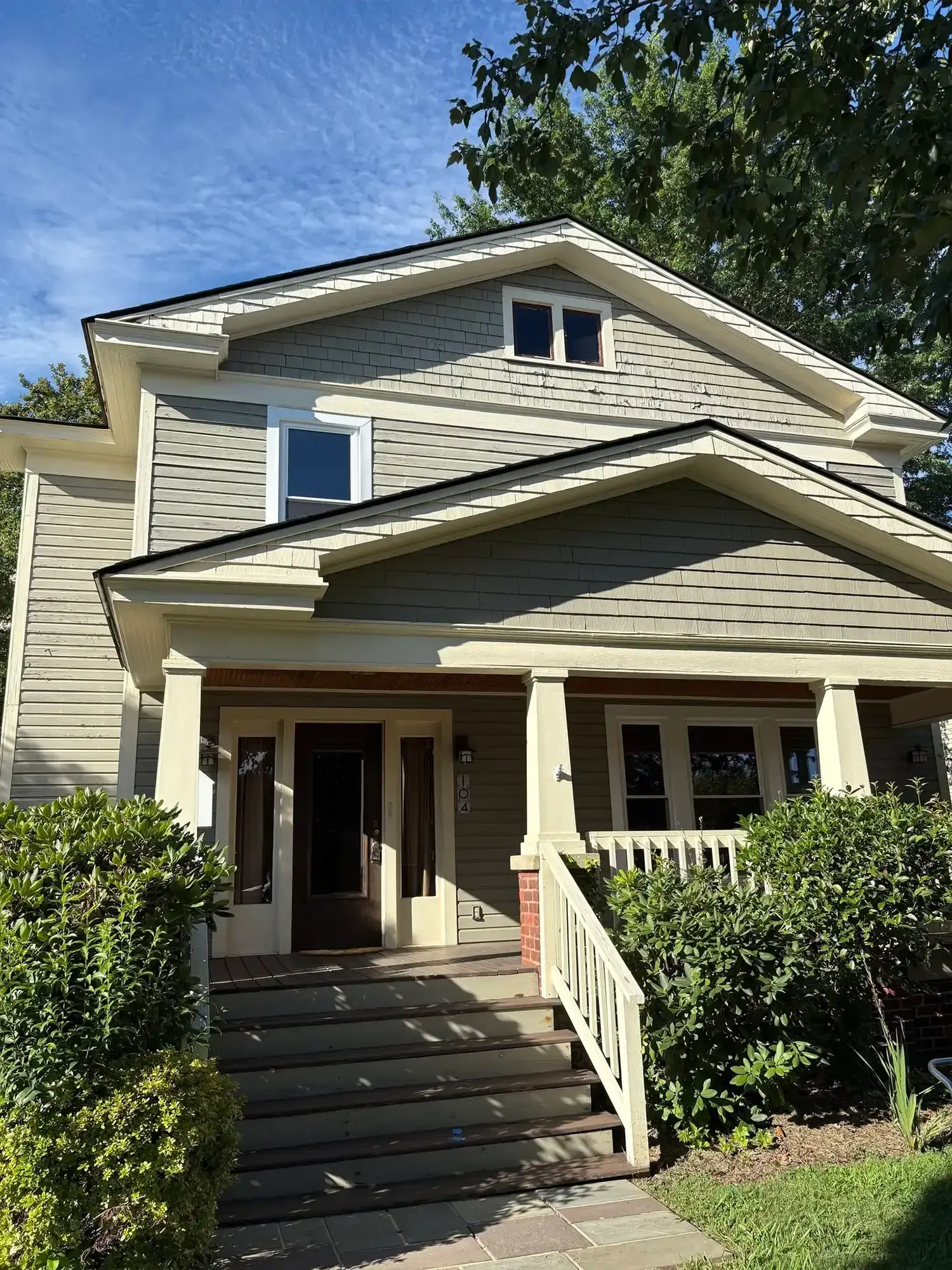 Freshly painted gray home exterior with white trim and front porch